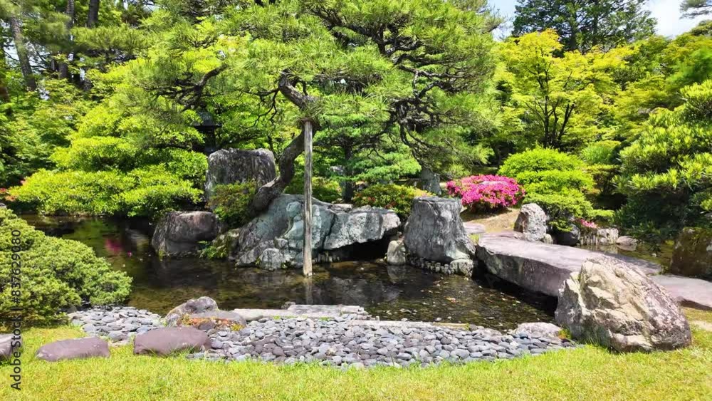 Japanese garden in Kyoto, Japan, with flowers, stones, water, and trees Japanese garden in Kyoto, Japan, with flowers, stones, water, and trees