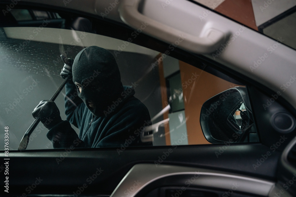Thief in uniform black jacket various action stolen cars. The Robber terrorism criminal car with balaclava and crowbar breaking into a car window Thief in uniform black jacket various action stolen cars. The Robber terrorism criminal car with balaclava and crowbar breaking into a car window
