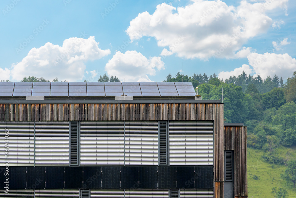 Fragment of a modern building with installed solar panels along the entire length of the roof Fragment of a modern building with installed solar panels along the entire length of the roof