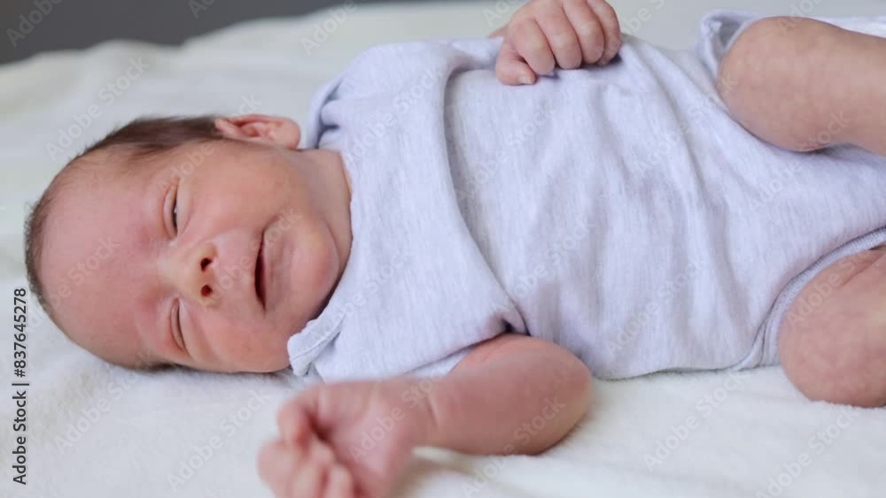 Adorable Caucasian baby wearing bodysuit lying comfortably on the bed at home child resting comfortably looking peaceful and innocent Adorable Caucasian baby wearing bodysuit lying comfortably on the bed at home child resting comfortably looking peaceful and innocent