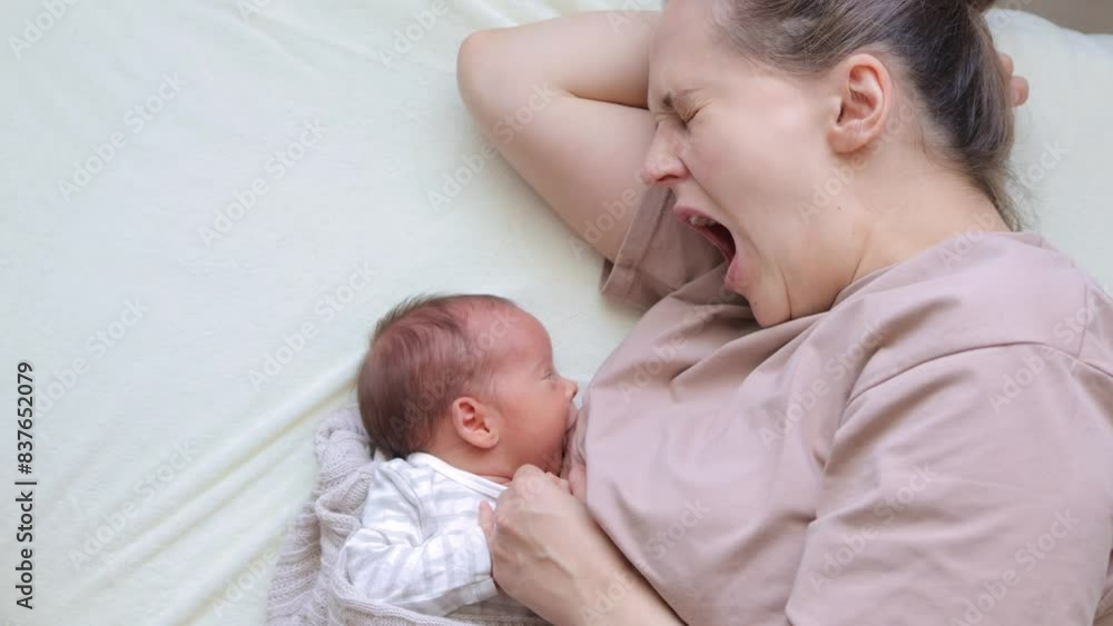 Caucasian mother breastfeeding newborn baby on a bed cute infant is drinking milk peacefully in the bedroom suckling calmly eating healthily in the nursery Caucasian mother breastfeeding newborn baby on a bed cute infant is drinking milk peacefully in the bedroom suckling calmly eating healthily in the nursery