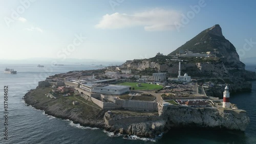 A wonderful high-flying drone shot showing the southernest point of Gibraltar at sunset with a single cloud above and the sea on either side.