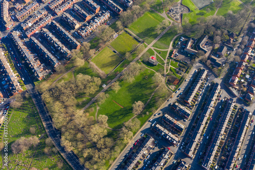 Aerial photo of the village of Beeston in Leeds West Yorkshire showing the Crossflatts Park along side rows of terrace houses, roads and streets, taken in the winter time on a wet cold day photo