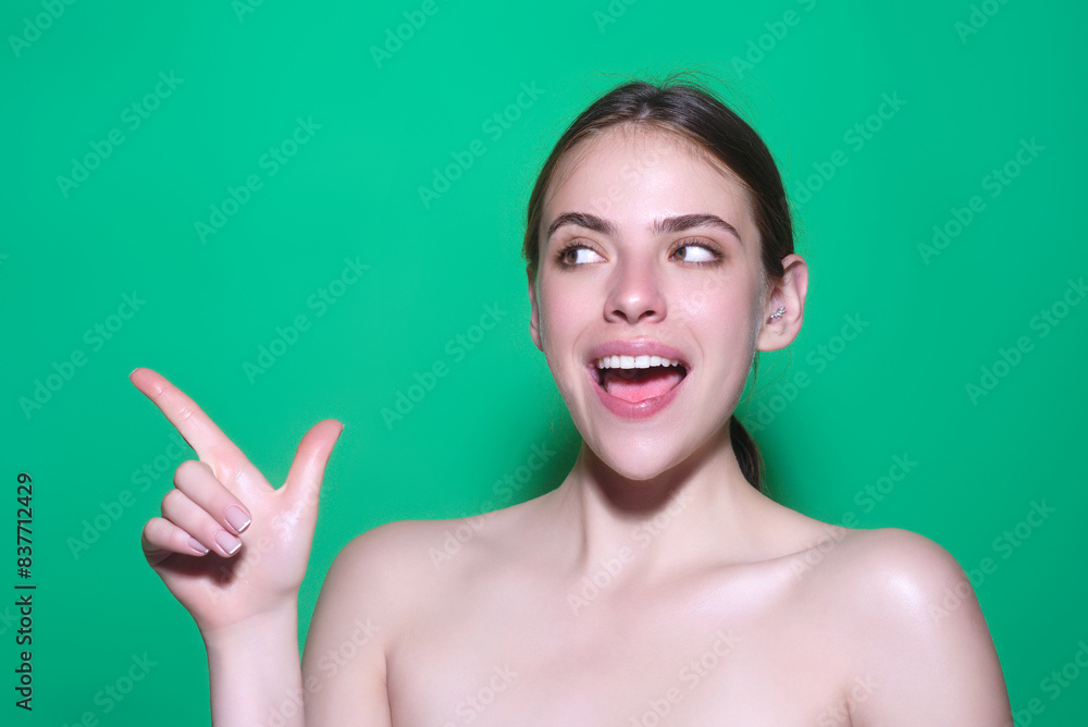 Young student pointing copy space. Studio portrait of Girl looking at camera and pointing away on isolated background. Woman point. Young student pointing copy space. Studio portrait of Girl looking at camera and pointing away on isolated background. Woman point.