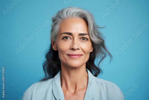 Woman, aged 55 and older, with a mesmerizing expression on a light blue background