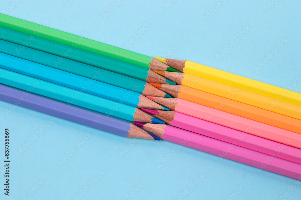 Pastel colored pencils on a blue background Pastel colored pencils on a blue background