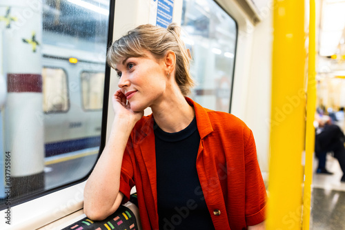 Young woman sitting in train and daydreaming photo