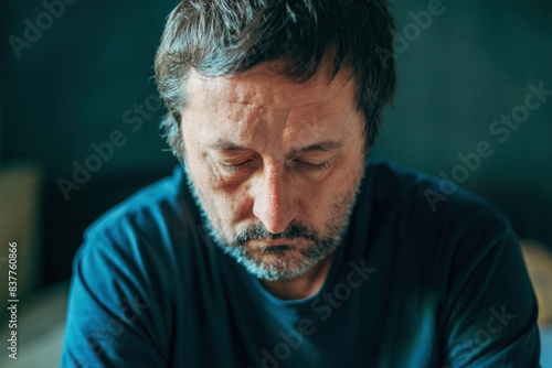 Papier peint Unhappy contemplative mature adult man thinking in dark room, depressed sulking
