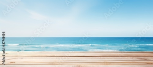 White wooden table with a serene background of blurred blue sky and sea, perfect as a copy space image for product displays or ads. © meristock
