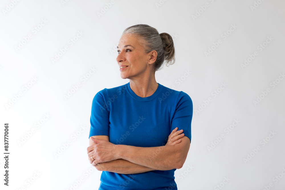 Senior woman with arms crossed in front of wall Senior woman with arms crossed in front of wall