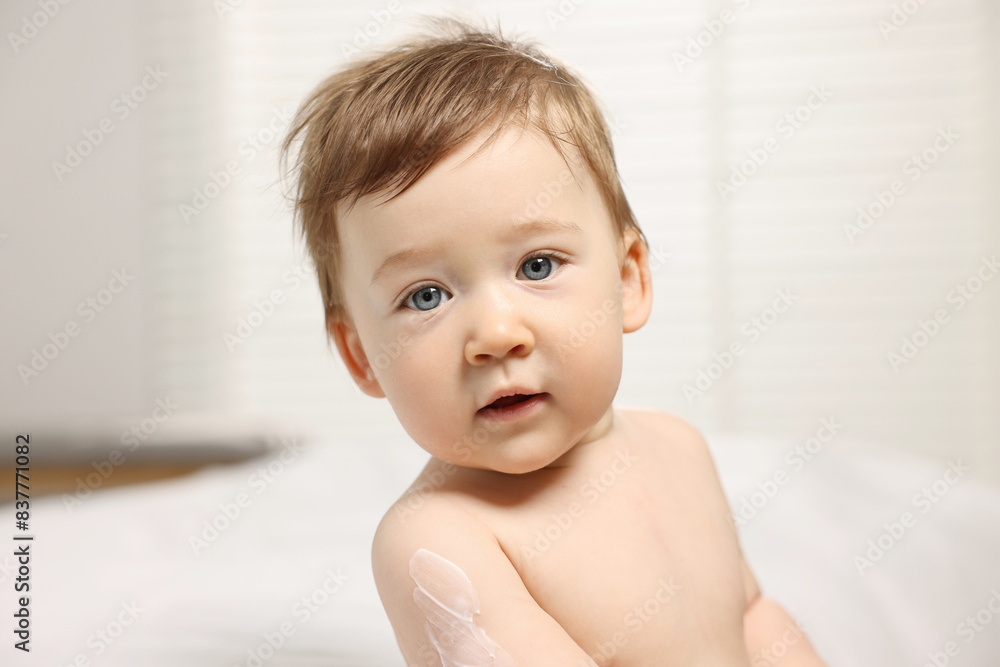 Cute little baby with moisturizing cream on body indoors Cute little baby with moisturizing cream on body indoors