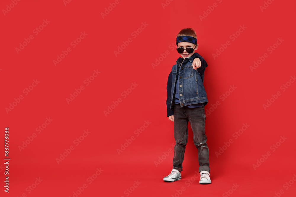 Happy little boy dancing on red background. Space for text Happy little boy dancing on red background. Space for text