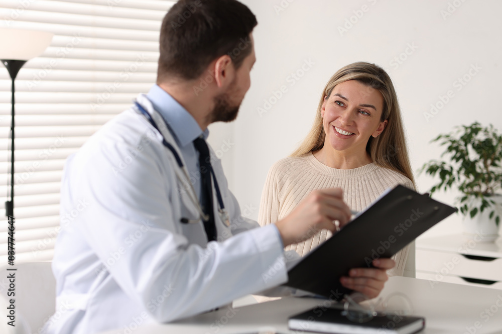 Professional doctor working with patient at white table in hospital Professional doctor working with patient at white table in hospital