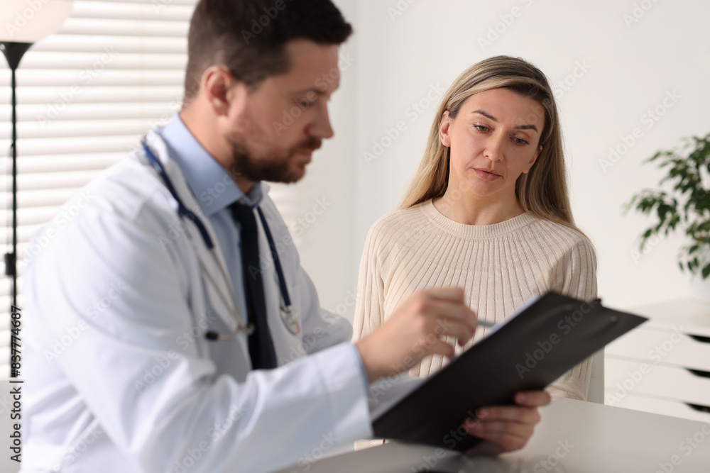 Professional doctor working with patient at white table in hospital Professional doctor working with patient at white table in hospital