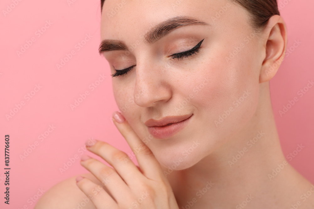 Fototapeta premium Makeup product. Woman with black eyeliner and beautiful eyebrows on pink background, closeup