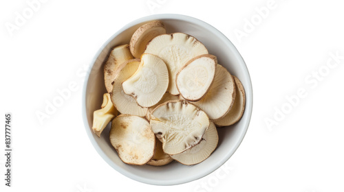 A white bowl filled with dried sliced lotus root, photographed from above on a white background