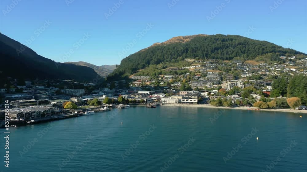 Low, wide aerial flying towards beach, buildings of Queenstown, New Zealand. Low, wide aerial flying towards beach, buildings of Queenstown, New Zealand.