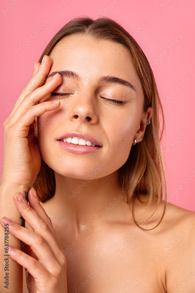 Portrait of a young woman with radiant skin and natural beauty on a pink background Portrait of a young woman with radiant skin and natural beauty on a pink background