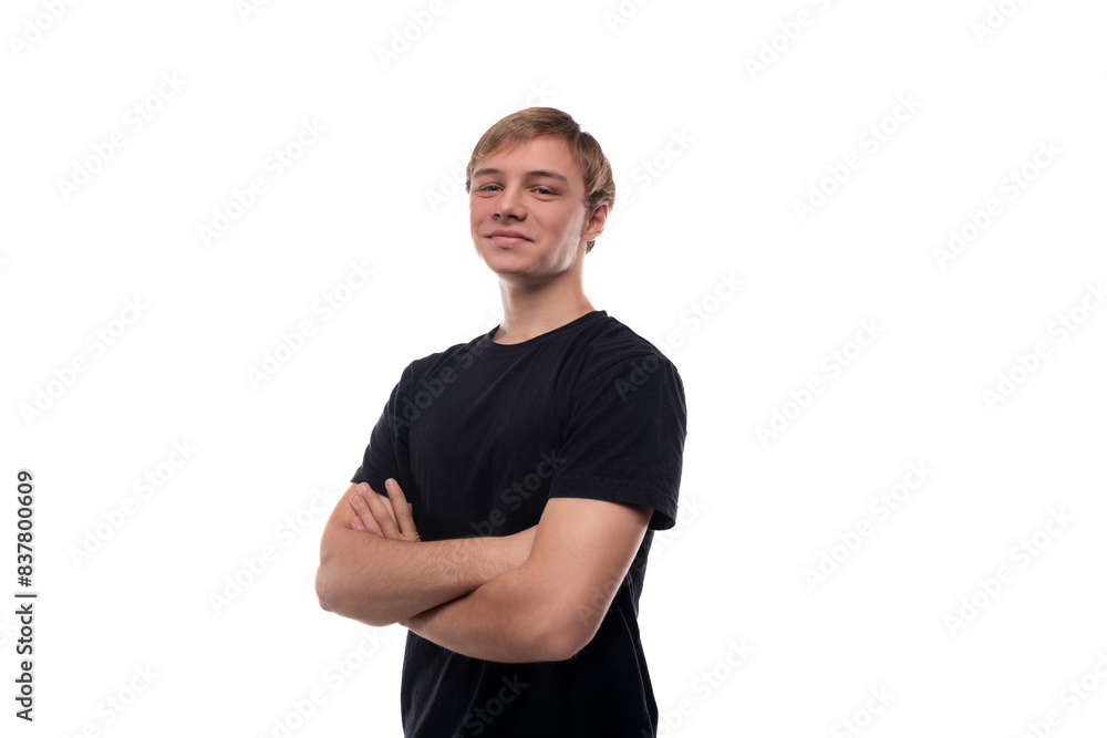 European blond teenager boy wearing a black T-shirt is proud of himself