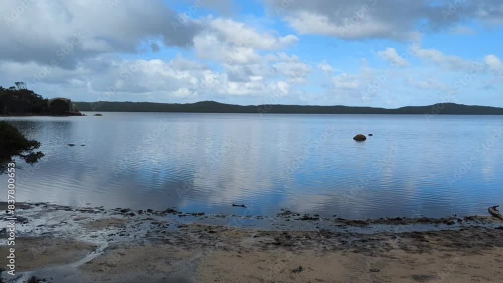 Beautiful blue waters and birds in 4k. Video taken at Big Cove in Denmark Western Australia. A slow pan from left to right. Calm blue waters reflect a cloud scattered sky with gentle ripples. Beautiful blue waters and birds in 4k. Video taken at Big Cove in Denmark Western Australia. A slow pan from left to right. Calm blue waters reflect a cloud scattered sky with gentle ripples.