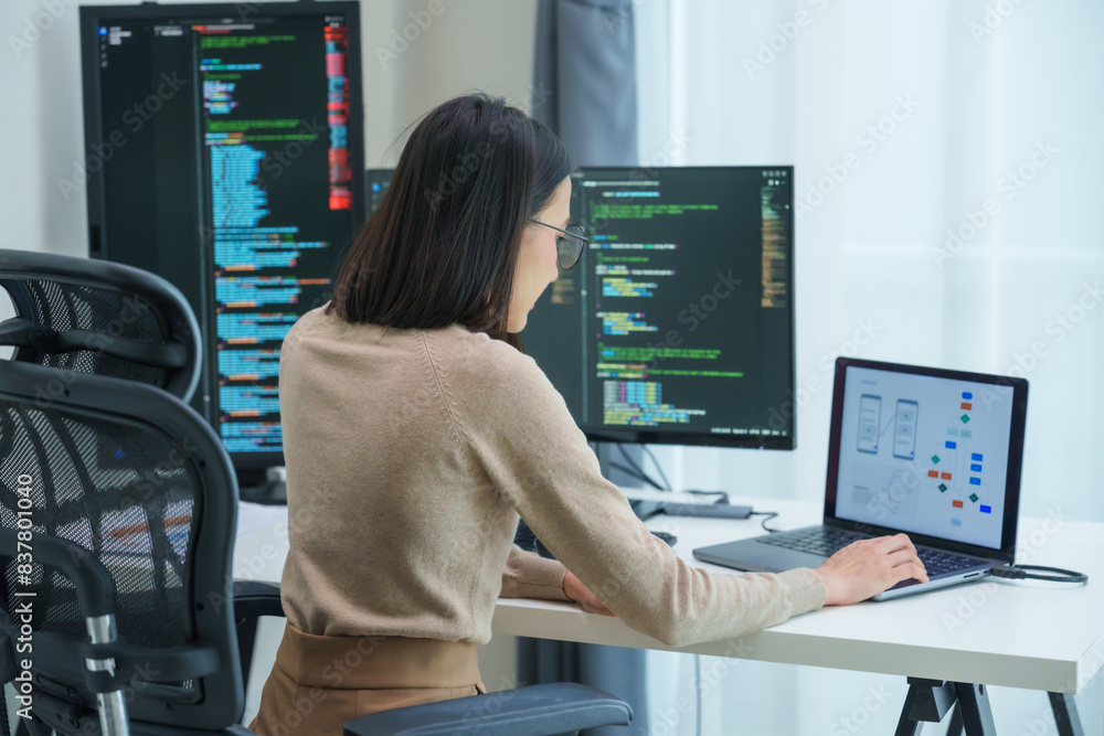 Asian prompt engineer develop coding app with software data sitting in front of computer monitor at office Asian prompt engineer develop coding app with software data sitting in front of computer monitor at office