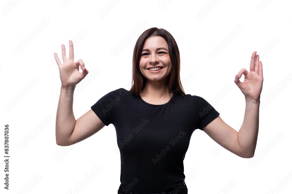 Caucasian cute young woman with black hair wearing a black T-shirt shows an excellent gesture Caucasian cute young woman with black hair wearing a black T-shirt shows an excellent gesture