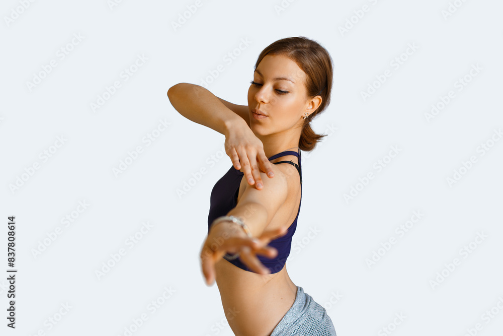 Beautiful woman in stylish clothes dances tribal fusion oriental dance on a white background