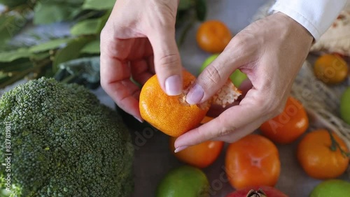 Peeling a tangerine, close up photo