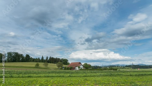 Cloudy sky moves over a farmhouse in Switzerland in summer. It's summer and nature is growing. Filmed in mönchaltorf. The Landscape are beautiful. photo