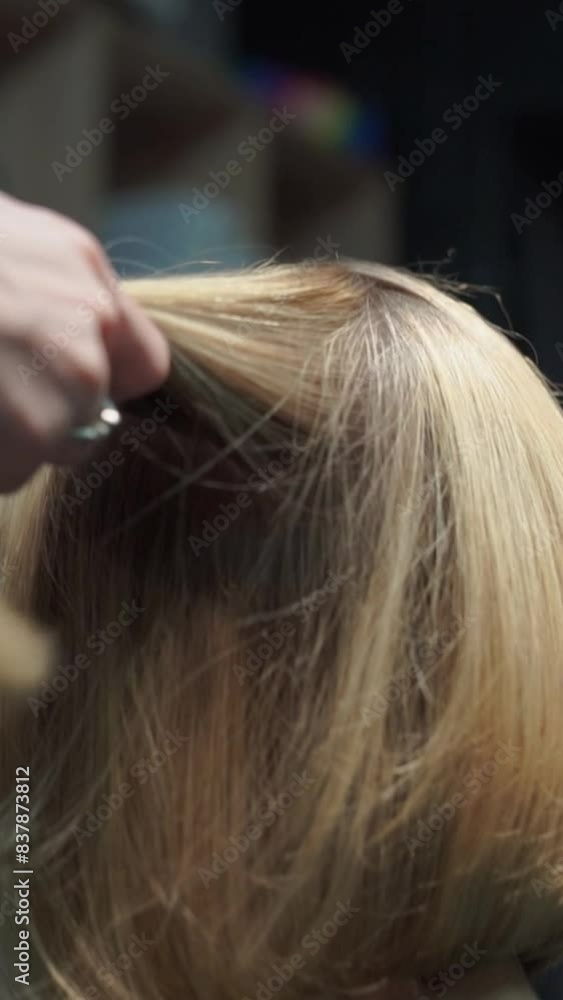 a beautiful young girl with short hair and a bob haircut is doing a procedure in a beauty salon. Hair master doing coloring and tone to client's hair close-up a beautiful young girl with short hair and a bob haircut is doing a procedure in a beauty salon. Hair master doing coloring and tone to client's hair close-up