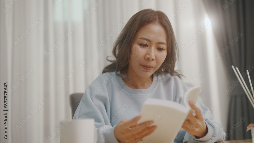 Woman reading a book in the living room While there was a coffee cup on the table. Woman reading a book in the living room While there was a coffee cup on the table.