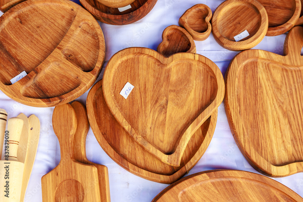 A collection of wooden plates and bowls, including a heart-shaped one A collection of wooden plates and bowls, including a heart-shaped one