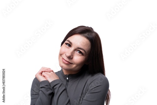 Young brunette woman smiling sweetly against a studio background with copy space