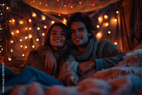 Couple enjoying a cozy night in watching a movie and cuddling © ChomchoeiFoto