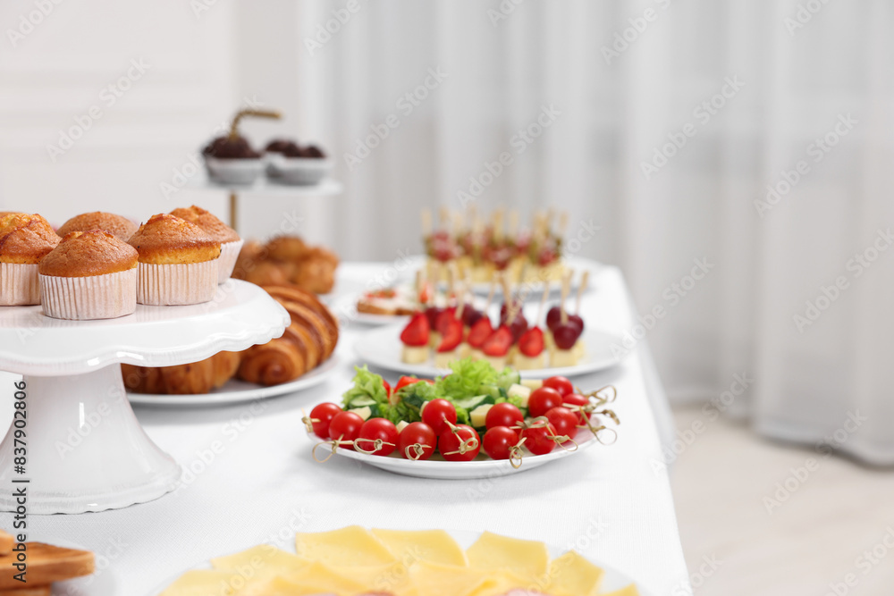 Different meals served on white table indoors. Buffet menu Different meals served on white table indoors. Buffet menu