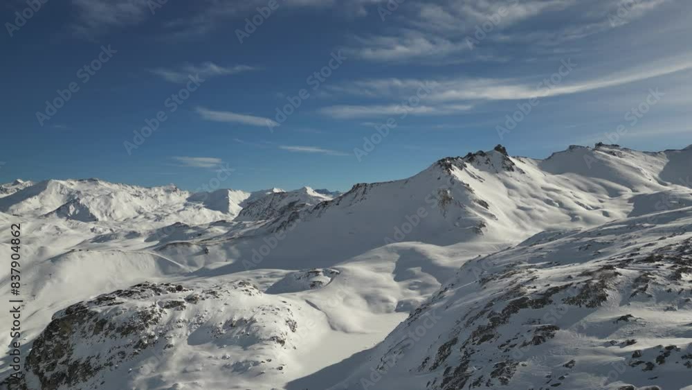 Drone shot of snowy mountains and ski slopes of Tignes in the French alps with a sunny cloudy sky Drone shot of snowy mountains and ski slopes of Tignes in the French alps with a sunny cloudy sky