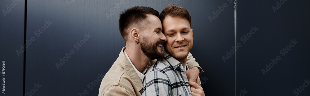 A cheerful gay couple standing close together outdoors. A cheerful gay couple standing close together outdoors.