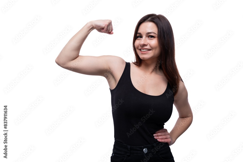 Happy young stylish woman with black hair showing strong muscles Happy young stylish woman with black hair showing strong muscles