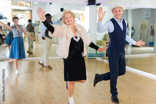 Senior woman and younger man dancing swing in studio photo