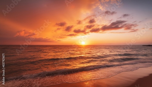 A fiery sunset paints the sky in vibrant hues of orange and purple as waves crash gently on the shore. 