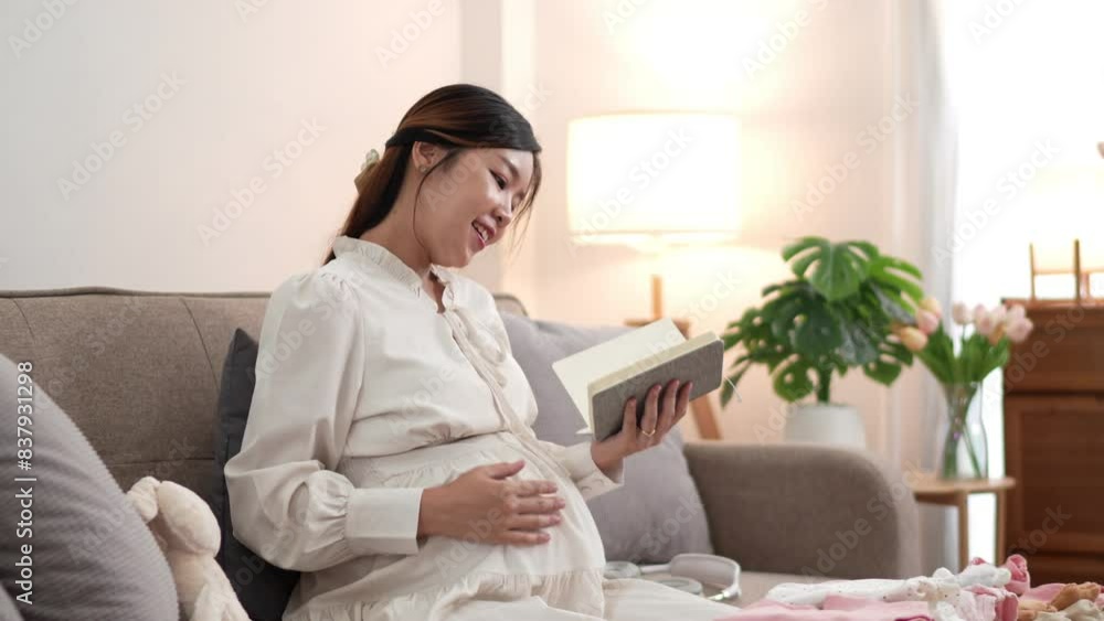 An Asian pregnant woman is reading a book to her unborn baby while sitting on the sofa at home.An Asian pregnant woman is reading a book to her unborn baby while sitting on the sofa at home An Asian pregnant woman is reading a book to her unborn baby while sitting on the sofa at home.An Asian pregnant woman is reading a book to her unborn baby while sitting on the sofa at home