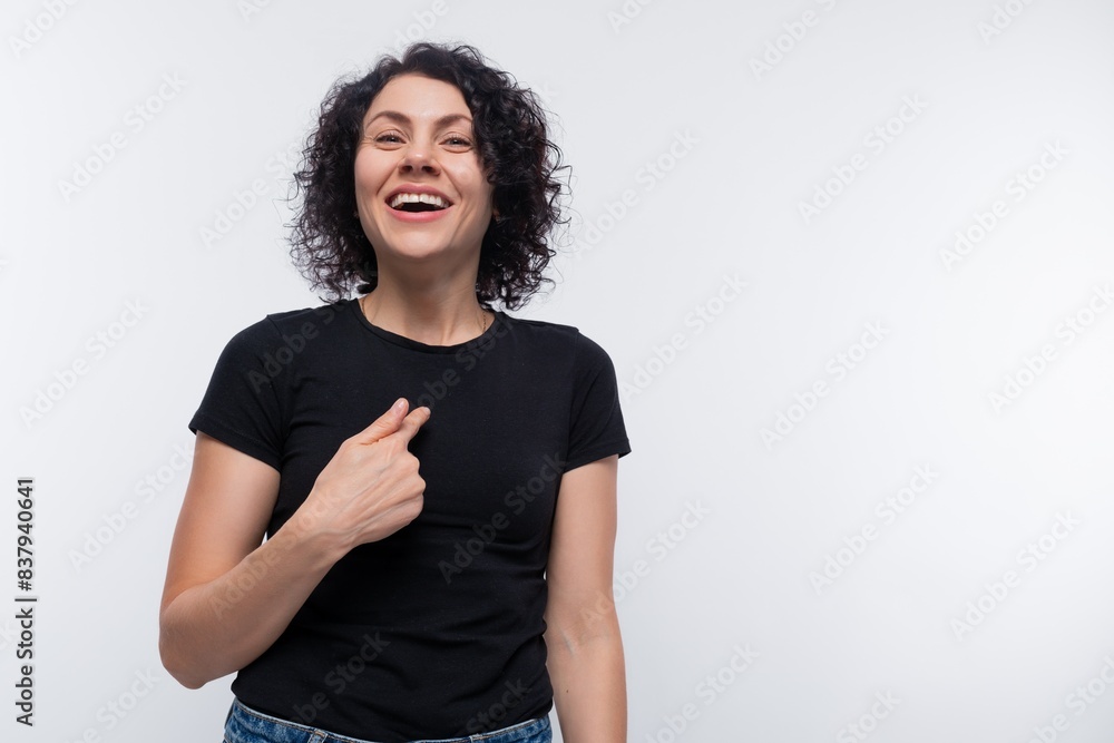 Caucasian woman with black curls acts cute and smiles Caucasian woman with black curls acts cute and smiles