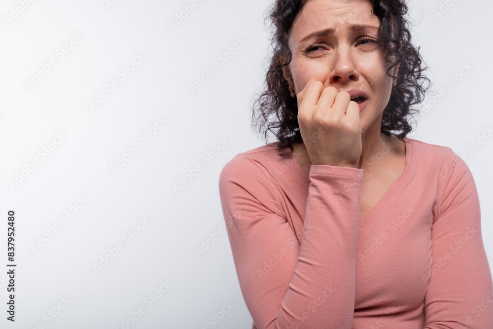 Sad brunette with curly hair in a pink blouse cries because of problems and worries about herself Sad brunette with curly hair in a pink blouse cries because of problems and worries about herself