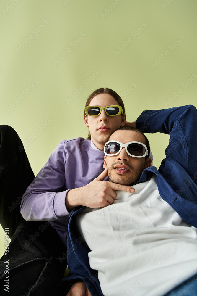 Two men sitting together, both wearing sunglasses. Two men sitting together, both wearing sunglasses.