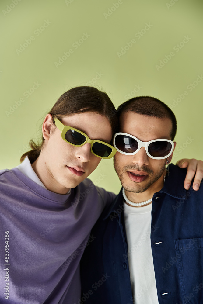 two men wearing sunglasses pose together for a picture. two men wearing sunglasses pose together for a picture.