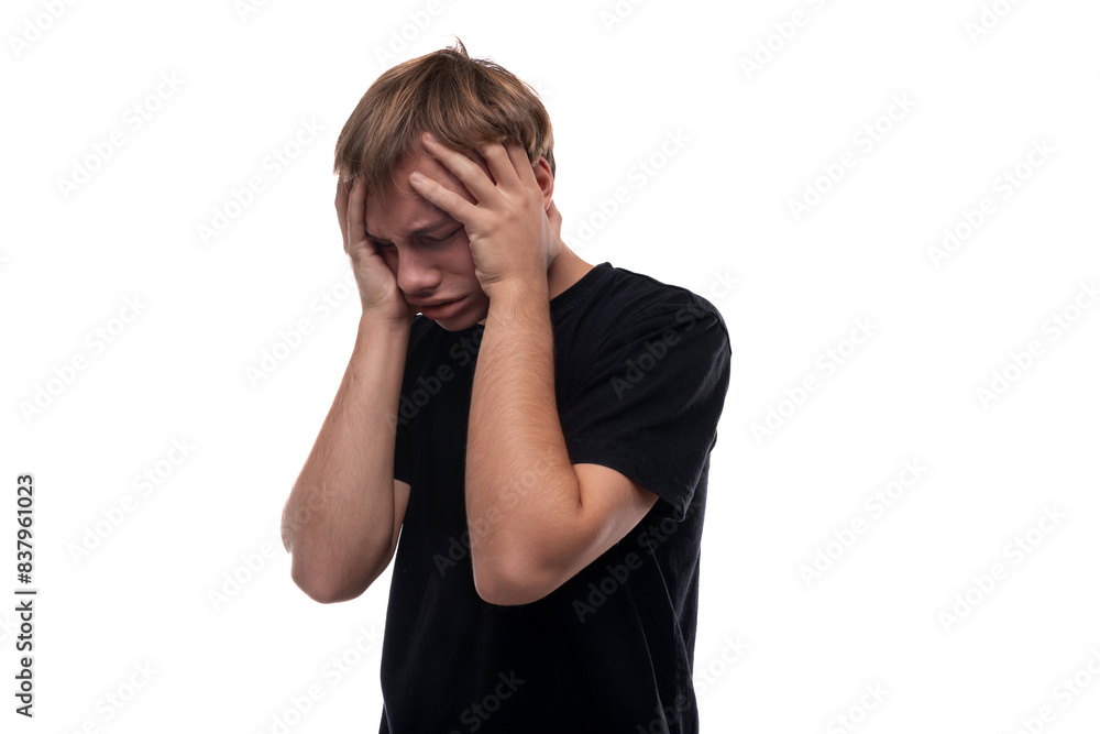 Headshot portrait of an unhappy blond Caucasian guy in a black T-shirt Headshot portrait of an unhappy blond Caucasian guy in a black T-shirt