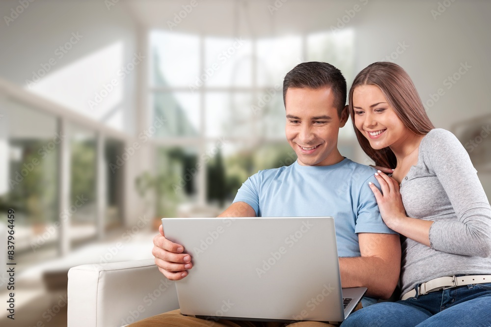 Happy young couple with laptop relaxing at home. Happy young couple with laptop relaxing at home.