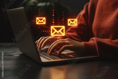 A person working on their laptop, surrounded by email icons popping up from the screen