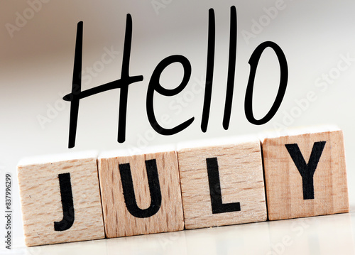 HELLO JULY word on a small chalk board on a light background.