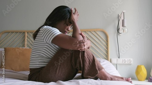 Desperate young Black woman sitting on bed feeling depressed and sad covering face with hands. 4k resolution video.